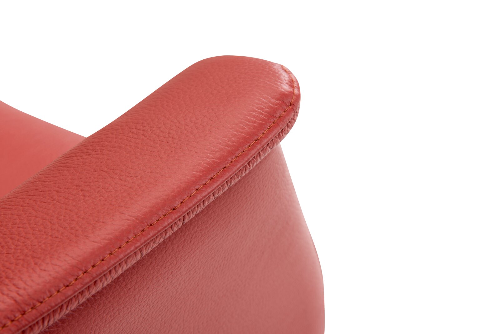 Close-up van een rode leren relaxfauteuil, met de nadruk op de armleuning.