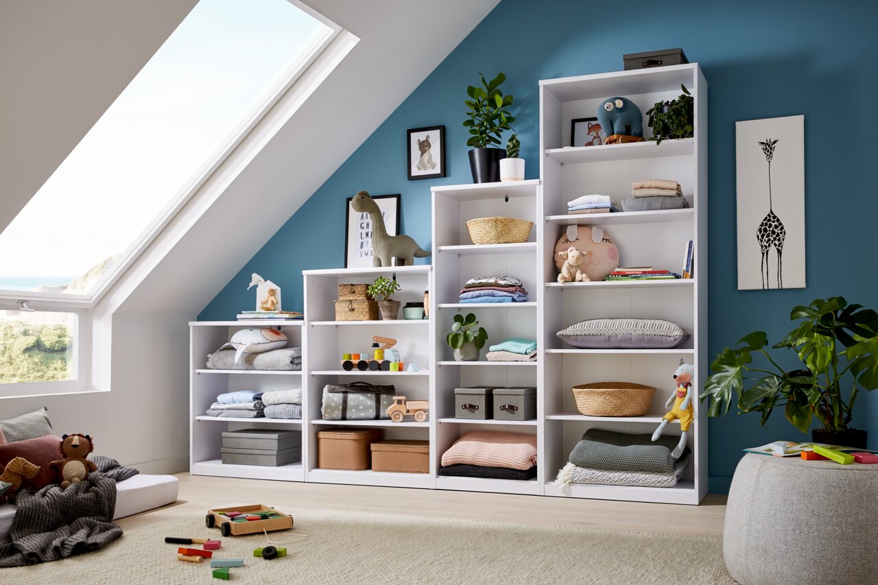 Helle, moderne Regale in einem gemütlichen Dachzimmer, gefüllt mit Spielzeug, Pflanzen und Dekorationen, seitliche Perspektive.