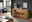 Holzsideboard MERAN in einem modernen Wohnzimmer, frontal fotografiert, mit dekorativen Elementen wie Vasen und Büchern darauf.