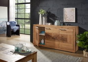 Holzsideboard MERAN in einem modernen Wohnzimmer, frontal fotografiert, mit dekorativen Elementen wie Vasen und Büchern darauf.