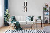 Moderne LED-Hängeleuchte in einem stilvollen Wohnzimmer, frontal betrachtet.