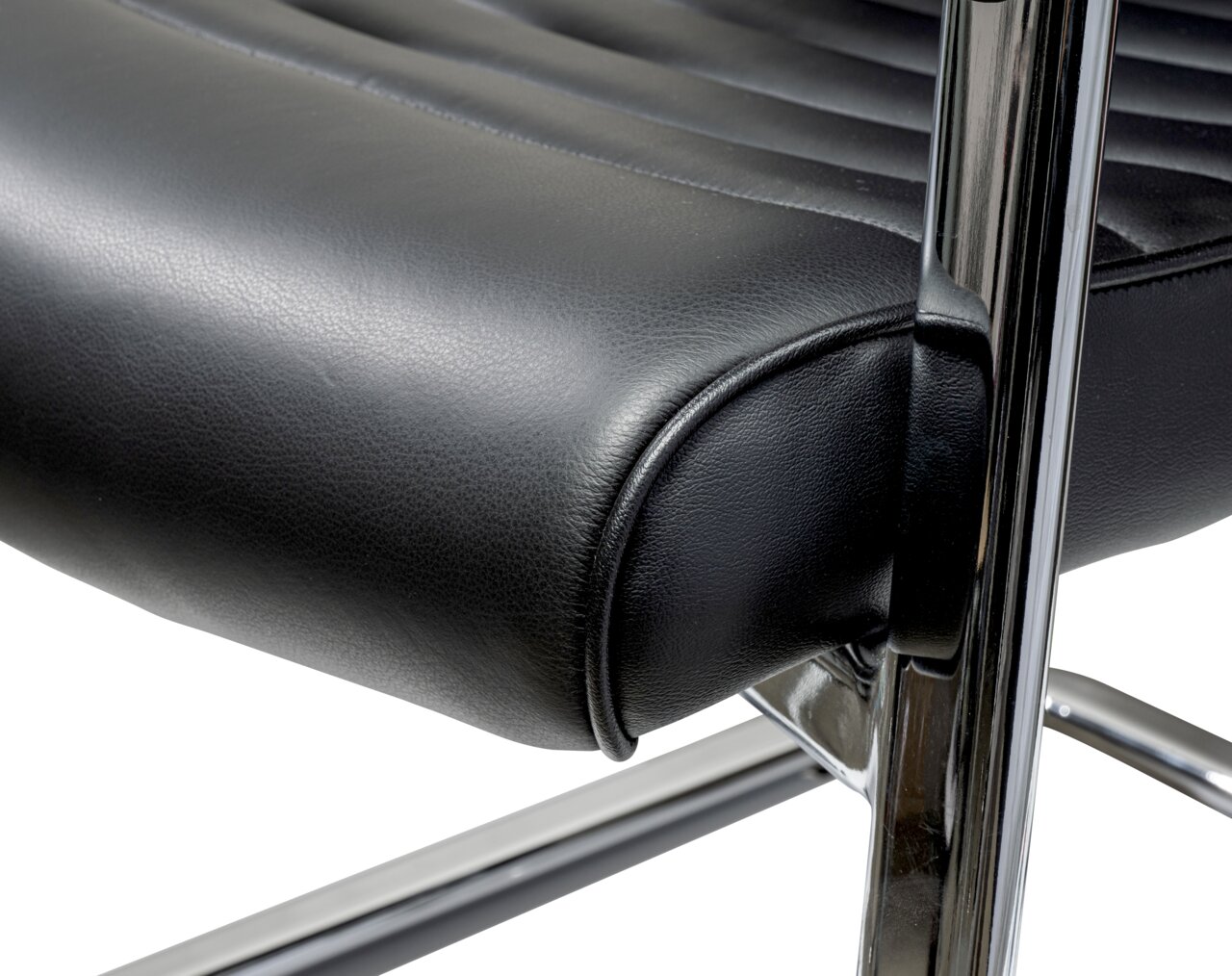 Nahaufnahme eines schwarzen Schwingstuhls mit verchromtem Gestell, seitliche Perspektive