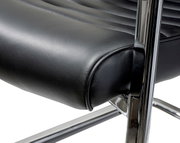 Close-up van een zwarte schommelstoel met verchroomd frame, zijaanzicht
