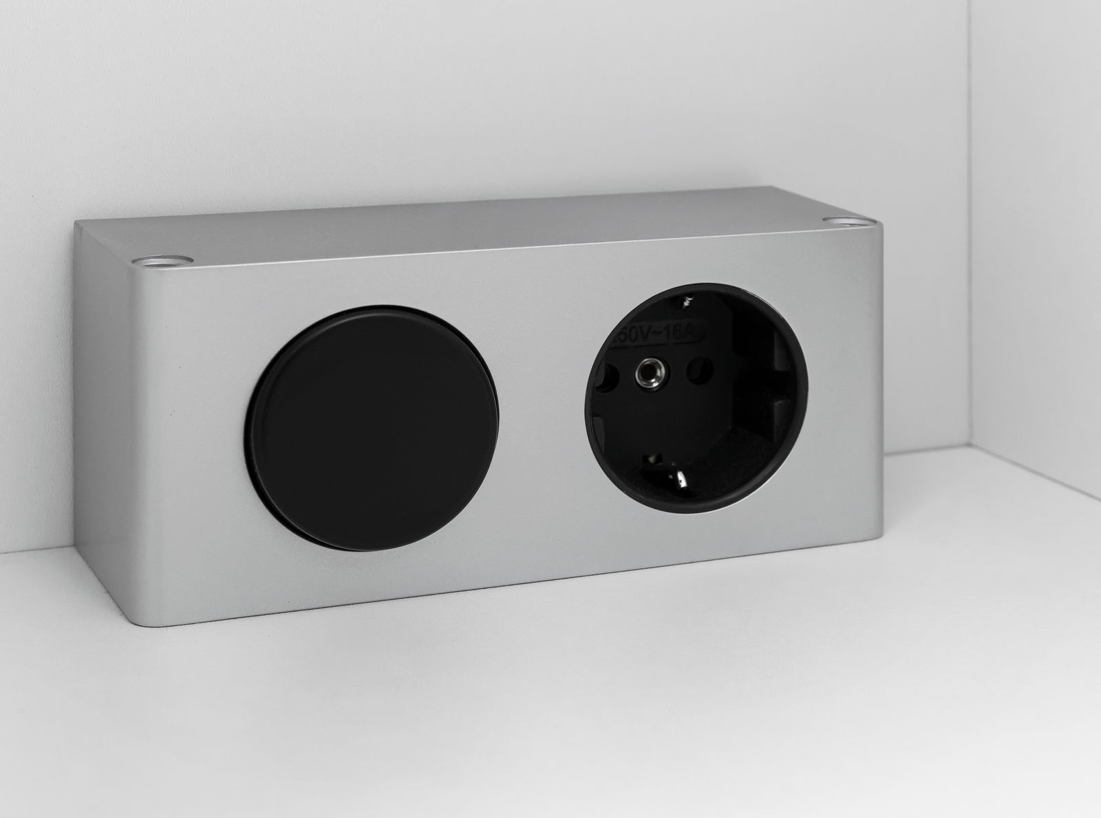 Silberne Steckdose mit einer schwarzen Abdeckung und einer Steckdose, seitliche Perspektive