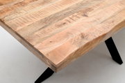 Nahaufnahme eines Esstisches aus hellem Holz mit natürlicher Maserung und schwarzen Metallbeinen, Perspektive von oben.