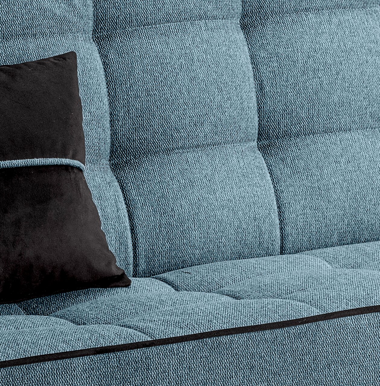Nahaufnahme eines blauen Schlafsofas mit schwarzem Kissen, Perspektive von der Seite