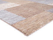 Nahaufnahme eines Frisé-Teppichs in Beige- und Grautönen, aus seitlicher Perspektive fotografiert.