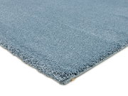 Blauer Uni-Teppich in Nahaufnahme, perspektivisch von der Seite fotografiert.