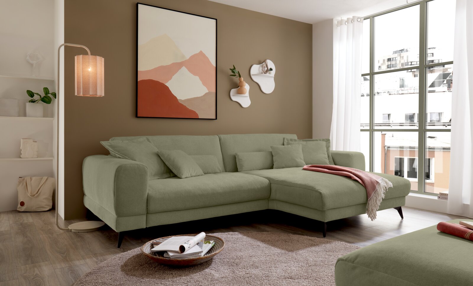 Set one by Musterring Ecksofa SET ONE MIDLAND Modernes hellgrünes Ecksofa mit Chaiselongue und Zierkissen im Wohnzimmer, seitliche Frontansicht von links, neben großem Fenster und Stehlampe