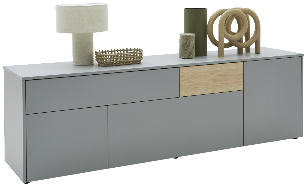 Voleo TV-Lowboard NAOMI Modernes TV-Lowboard in Grau mit Holzakzent, dekoriert mit einer Tischlampe, einem Korb und weiteren Accessoires, seitliche Perspektive.