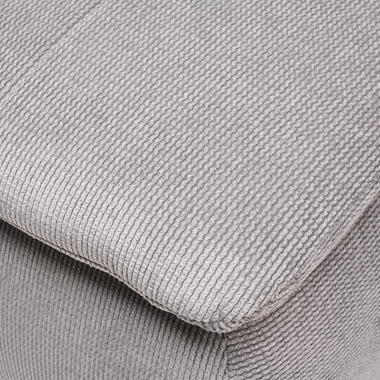 Nahaufnahme eines grauen, strukturierten Stoffes eines Boxspring-Funktionssofas, perspektivisch von oben fotografiert.