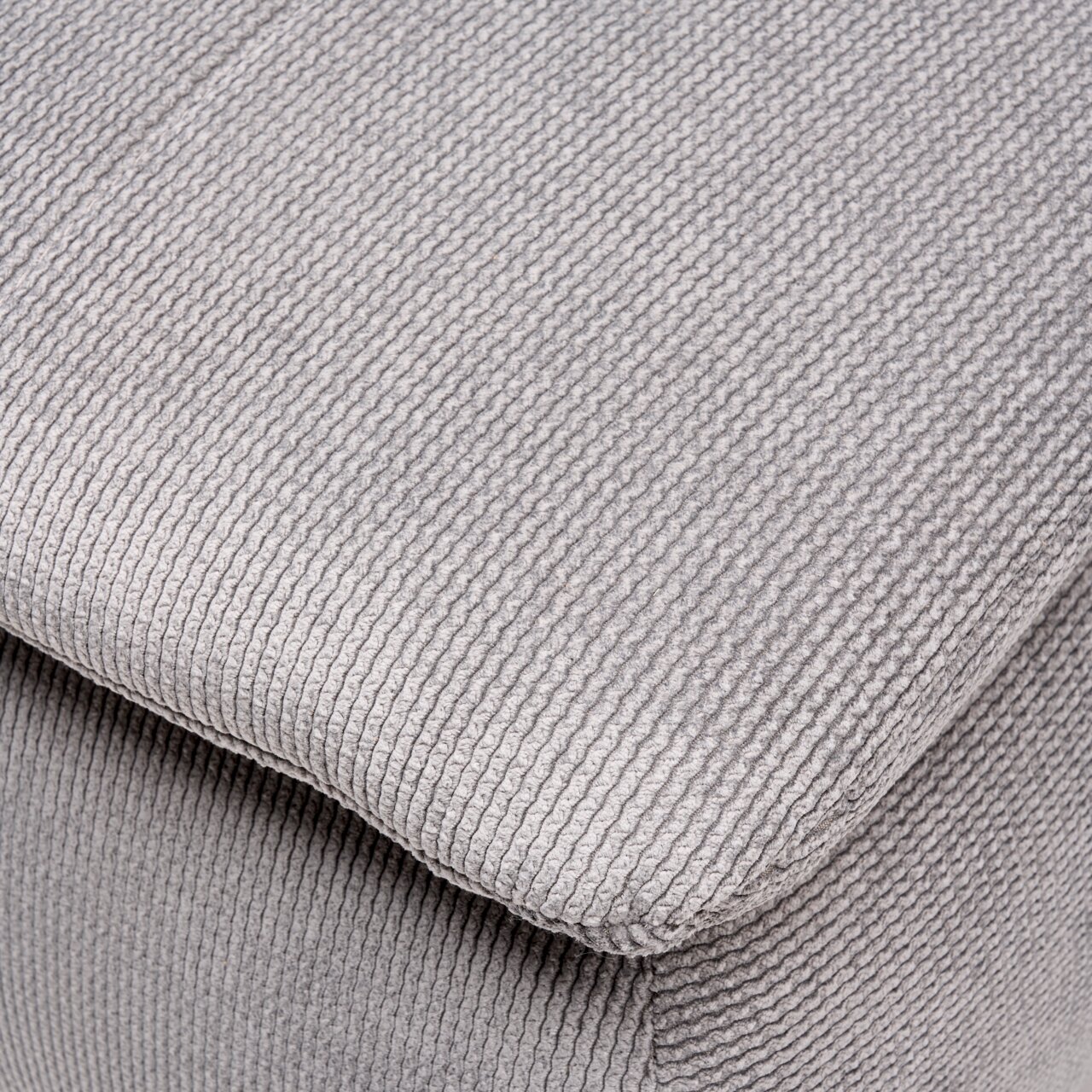 Nahaufnahme eines grauen, strukturierten Stoffes eines Boxspring-Funktionssofas, perspektivisch von oben fotografiert.