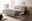 Modernes Polsterbett in einem hellen Schlafzimmer, seitliche Perspektive, mit dekorativen Kissen und Decken, umgeben von minimalistischer Einrichtung.