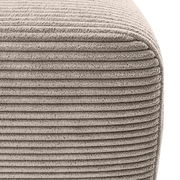 Nahaufnahme einer strukturierten, gerippten Stoffoberfläche eines Ecksofas in Beige, perspektivisch von der Seite aufgenommen.