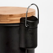 Nahaufnahme eines schwarzen Kosmetikeimers mit Holzdeckel und Metallgriff