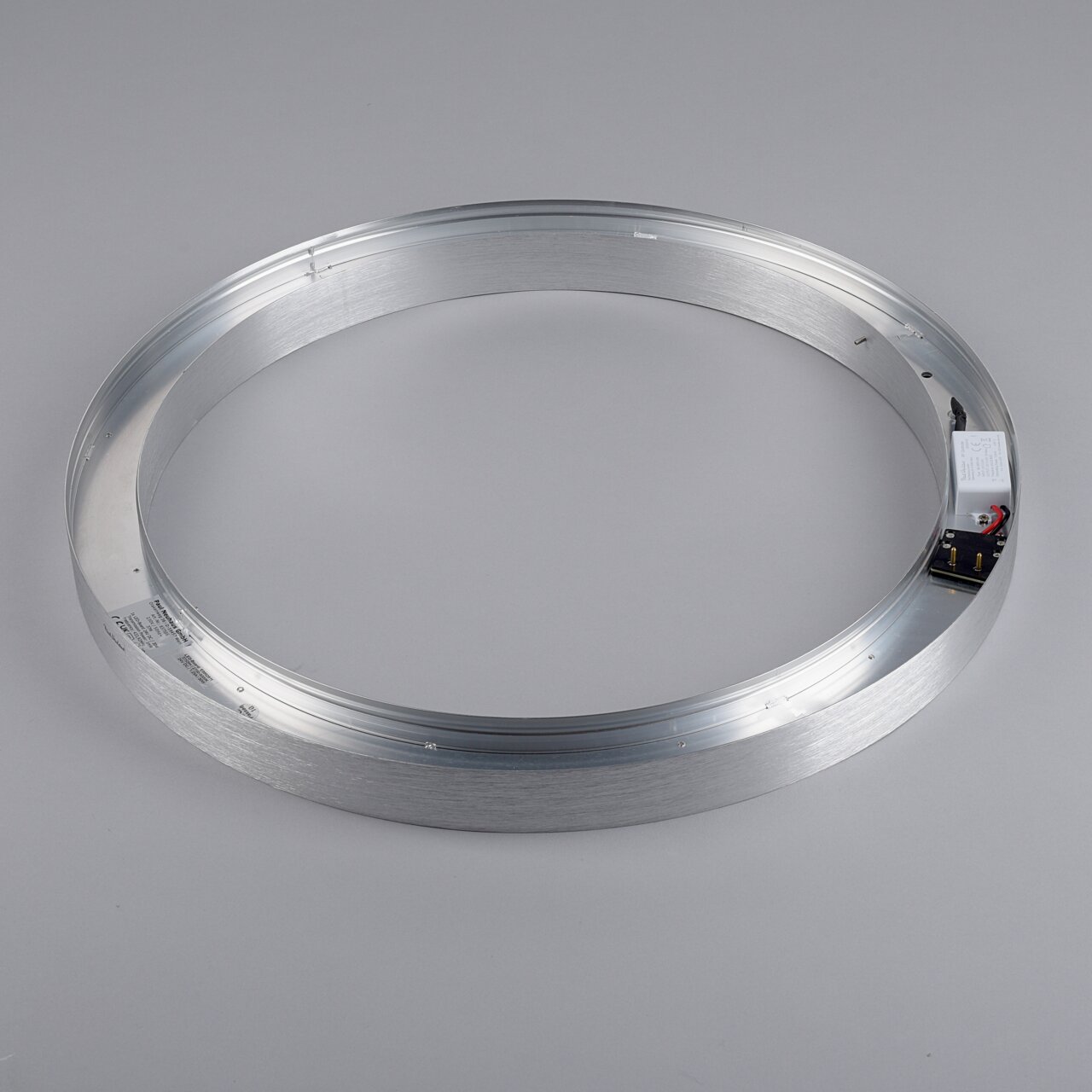 Runde Metallstruktur einer Deckenleuchte, von oben betrachtet, mit sichtbaren elektrischen Komponenten.