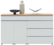 Frontale Ansicht eines modernen Sideboards mit weißer Oberfläche und Holzplatte, dekoriert mit einer Vase, einer Schale und einem offenen Buch.