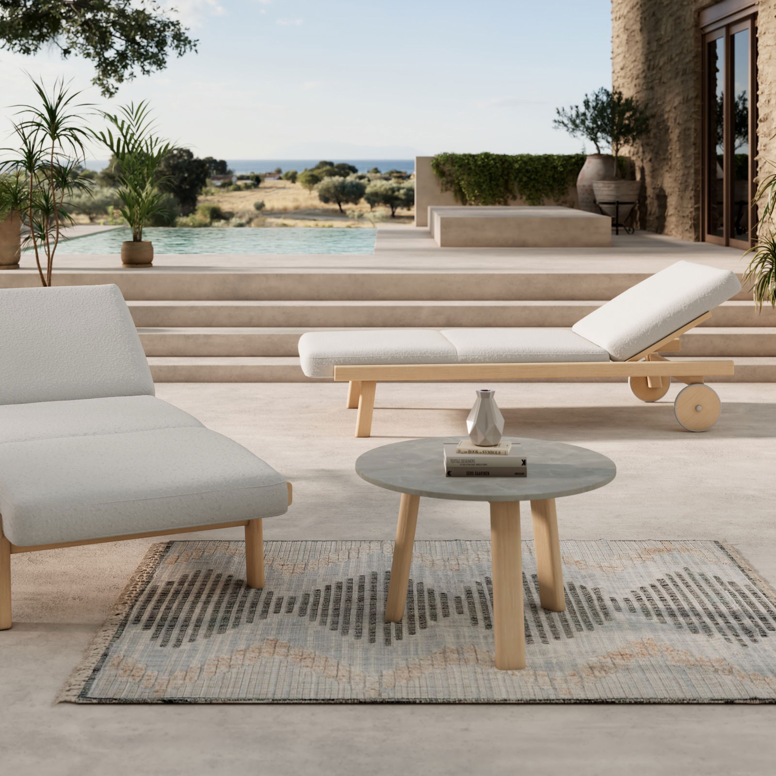 Dieter Knoll Sonnenliege MARI Moderne Gartenlounge mit Sonnenliege und rundem Loungetisch auf Terrasse mit Blick auf Pool und Landschaft, seitliche Perspektive.