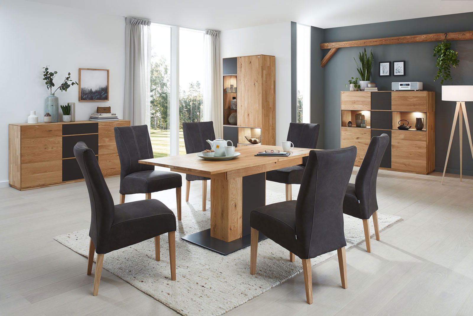 Moderner Essbereich mit Holztisch und sechs gepolsterten Stühlen in einem hellen Raum, seitliche Perspektive.