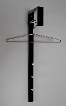 Zurbrüggen Wandgarderobe Schwarze Wandgarderobe mit vertikaler Metallschiene und ausklappbarem Drahtkleiderbügel, frontal aus leicht seitlicher Perspektive vor grauem Hintergrund