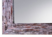 Nahaufnahme eines rechteckigen Spiegels mit rustikalem Holzrahmen in verschiedenen Brauntönen.