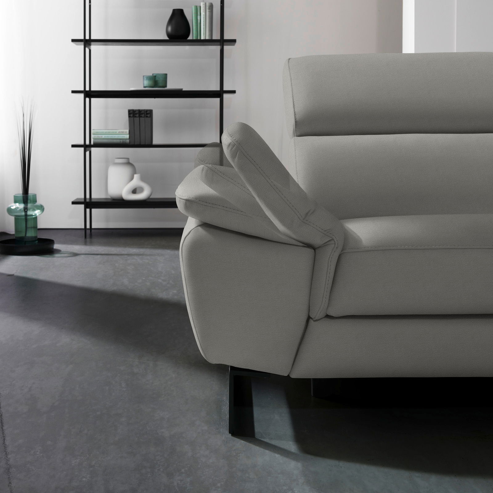 Graues Ecksofa NAPOLI von Celina Home mit verstellbarer Armlehne, seitliche Perspektive.