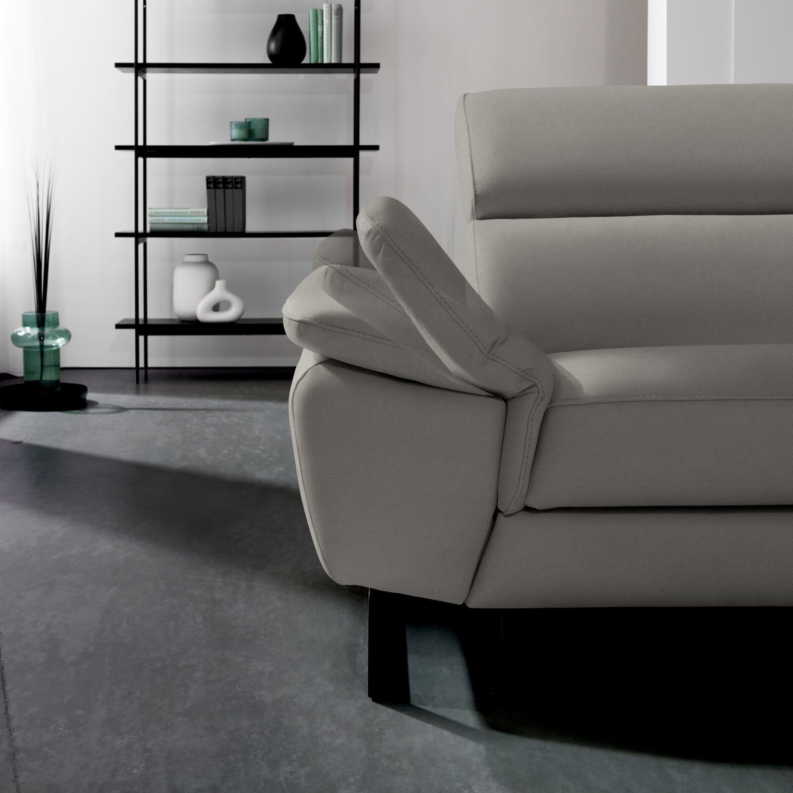 Graues Ecksofa NAPOLI von Celina Home mit verstellbarer Armlehne, seitliche Perspektive.