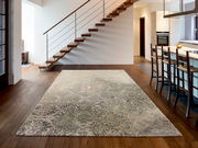 Designer Teppich in modernem Wohnzimmer mit Holztreppe und Küchenbereich, Perspektive von vorne