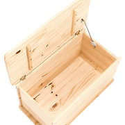 Geöffnete Aufbewahrungstruhe aus hellem Holz mit sichtbaren Scharnieren und Stütze, von oben betrachtet.