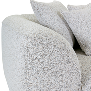 Nahaufnahme eines Big-Sofas mit hellgrauem Stoffbezug und mehreren Kissen, seitliche Perspektive.