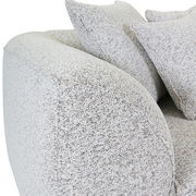 Nahaufnahme eines Big-Sofas mit hellgrauem Stoffbezug und mehreren Kissen, seitliche Perspektive.