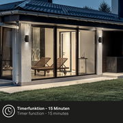 Moderne Akku-Außenwandleuchte an einer Hauswand in der Abenddämmerung, seitliche Perspektive