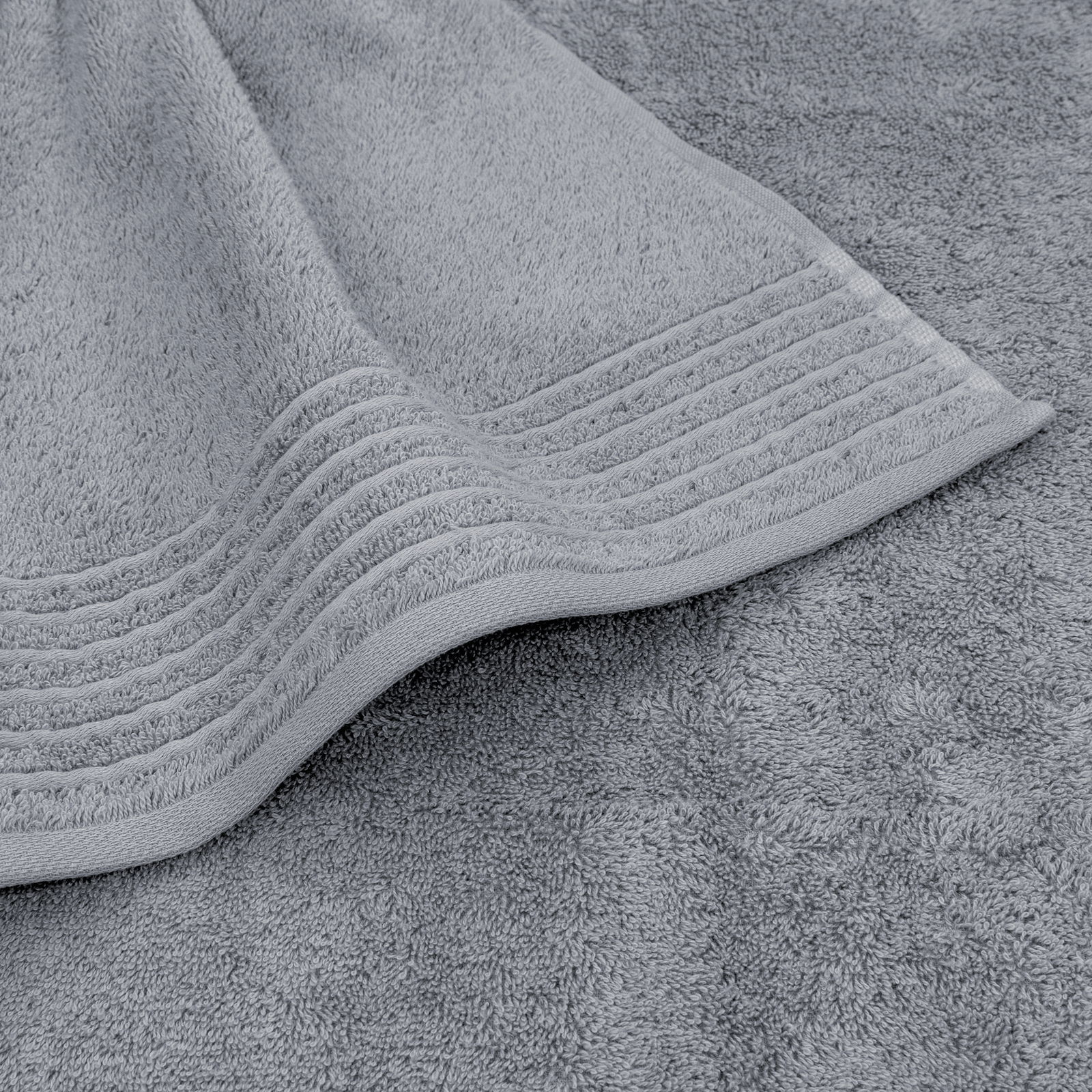 Graues Handtuchset mit feiner Struktur und dekorativen Streifen, Nahaufnahme von oben.