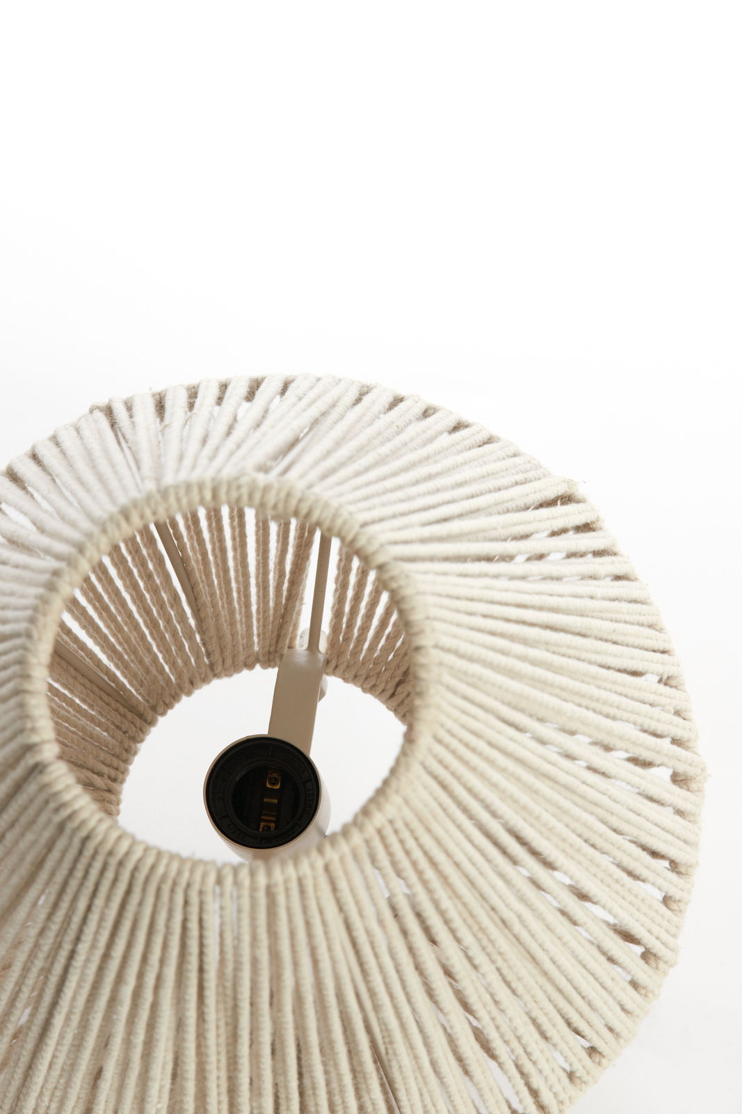 Ansicht von oben auf eine Tischleuchte mit einem Lampenschirm aus geflochtenem, cremefarbenem Material.