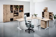 Moderne Büromöbel in Holzoptik mit Schreibtisch, Regalen und ergonomischem Stuhl, seitliche Perspektive
