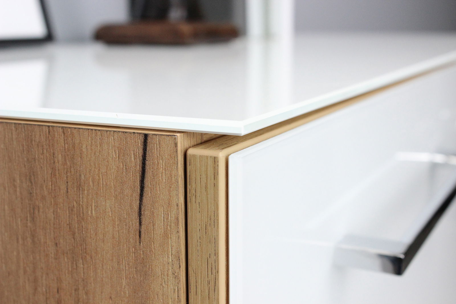 Nahaufnahme eines modernen Aktenschranks mit Holz- und Weißglas-Elementen, seitliche Perspektive.