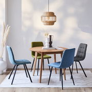 Runder Esstisch aus Holz mit vier bunten Stühlen, aus der Perspektive leicht von oben betrachtet, in einem modernen Esszimmer mit hängender Lampe und Dekoration.