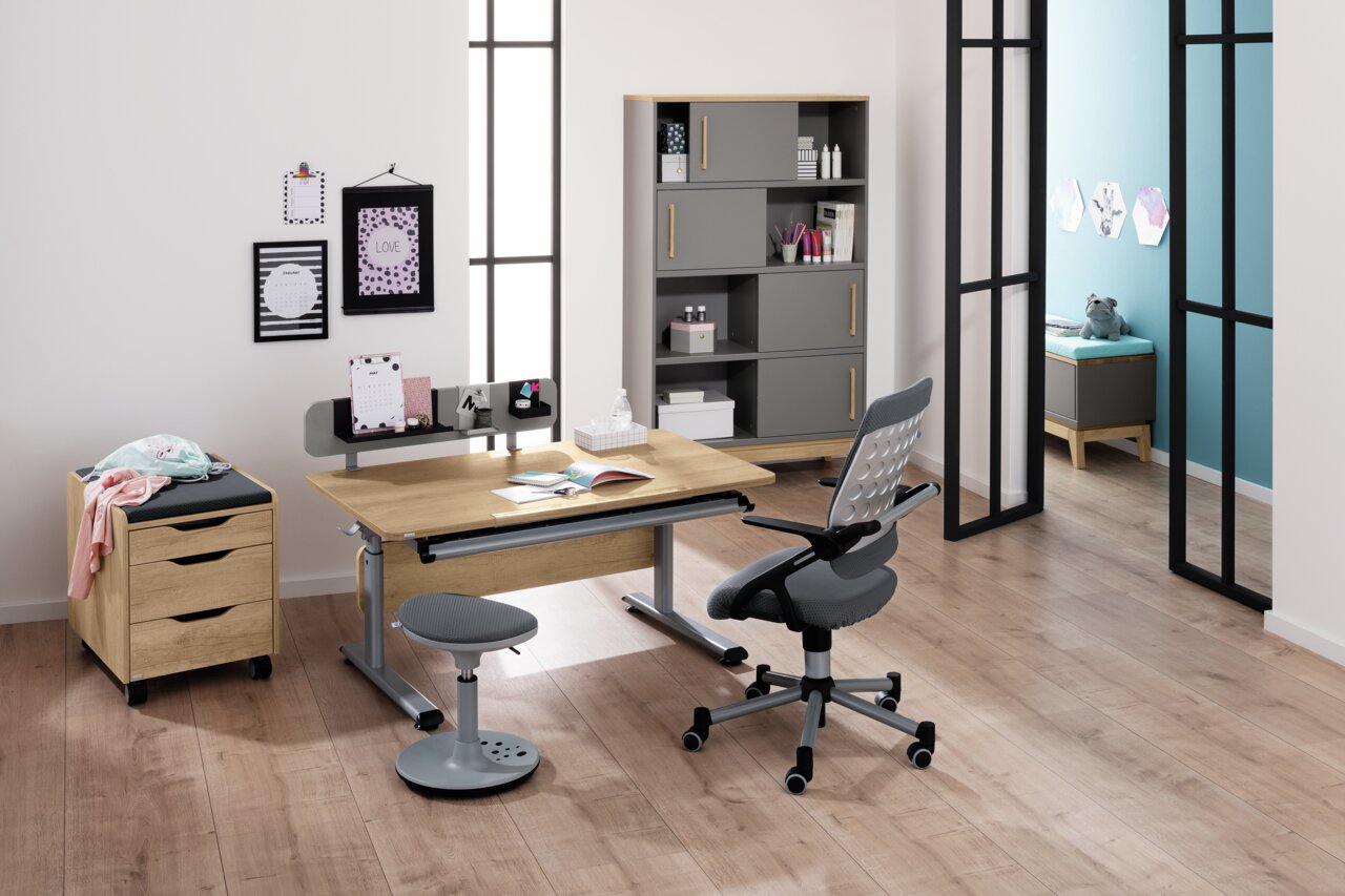 Moderner Schreibtisch in einem stilvollen Büro mit Holz- und Metallelementen, umgeben von einem ergonomischen Stuhl und einem Rollcontainer, aus der Frontalperspektive betrachtet.