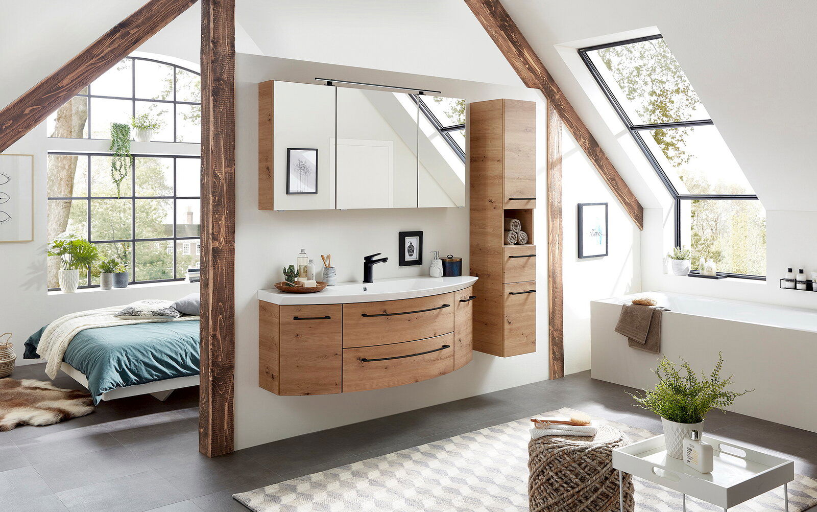 Moderner Hochschrank aus Holz in einem stilvollen Badezimmer mit Dachschräge, neben einem Waschtisch und Spiegeln, mit Blick auf ein großes Fenster.