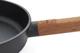 Nahaufnahme einer Gusspfanne mit Holzgriff, seitliche Perspektive