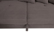 Nahaufnahme einer grauen, gerippten Polsteroberfläche eines Sofas, von oben betrachtet.