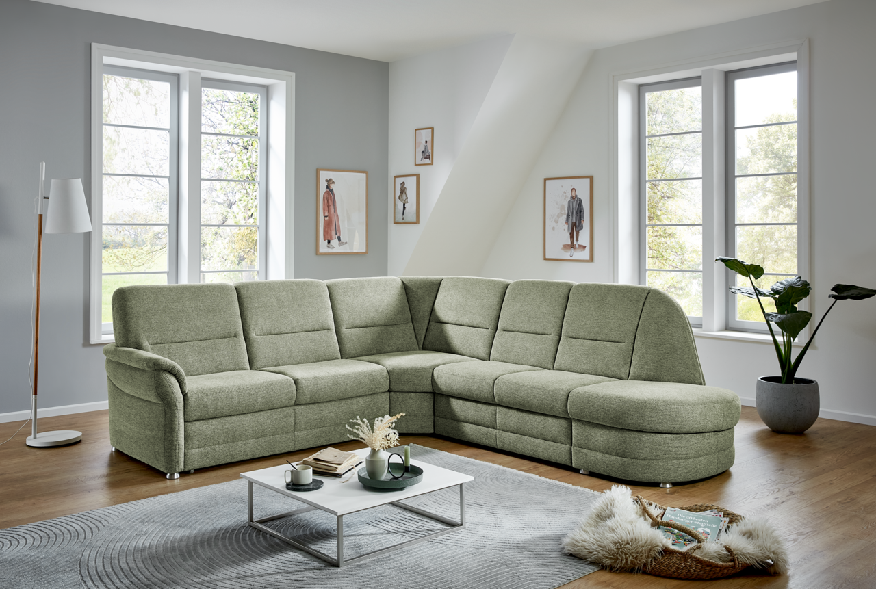 Grüne Eckgarnitur Beldomo Comfort QUEENLINE in einem modernen Wohnzimmer, seitliche Perspektive.