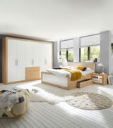 Modernes Schlafzimmer mit einer Kommode aus Holz und weißen Elementen, seitliche Perspektive.