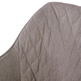 Nahaufnahme der Rückenlehne eines Armlehnstuhls mit strukturierter, beiger Polsterung in diagonaler Perspektive.