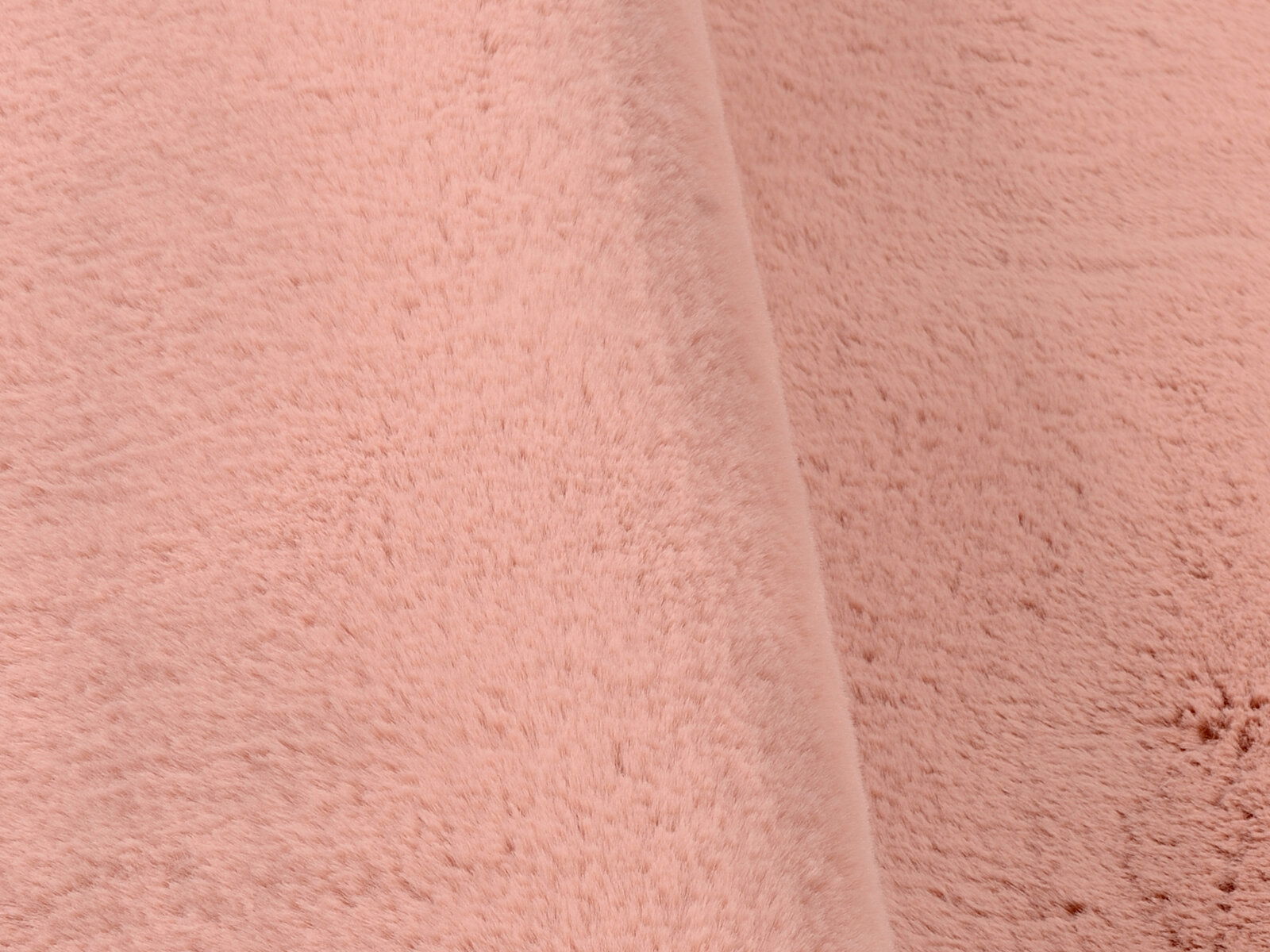 Nahaufnahme eines rosafarbenen Fellteppichs in weicher Textur, seitliche Perspektive