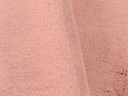 Nahaufnahme eines rosafarbenen Fellteppichs in weicher Textur, seitliche Perspektive