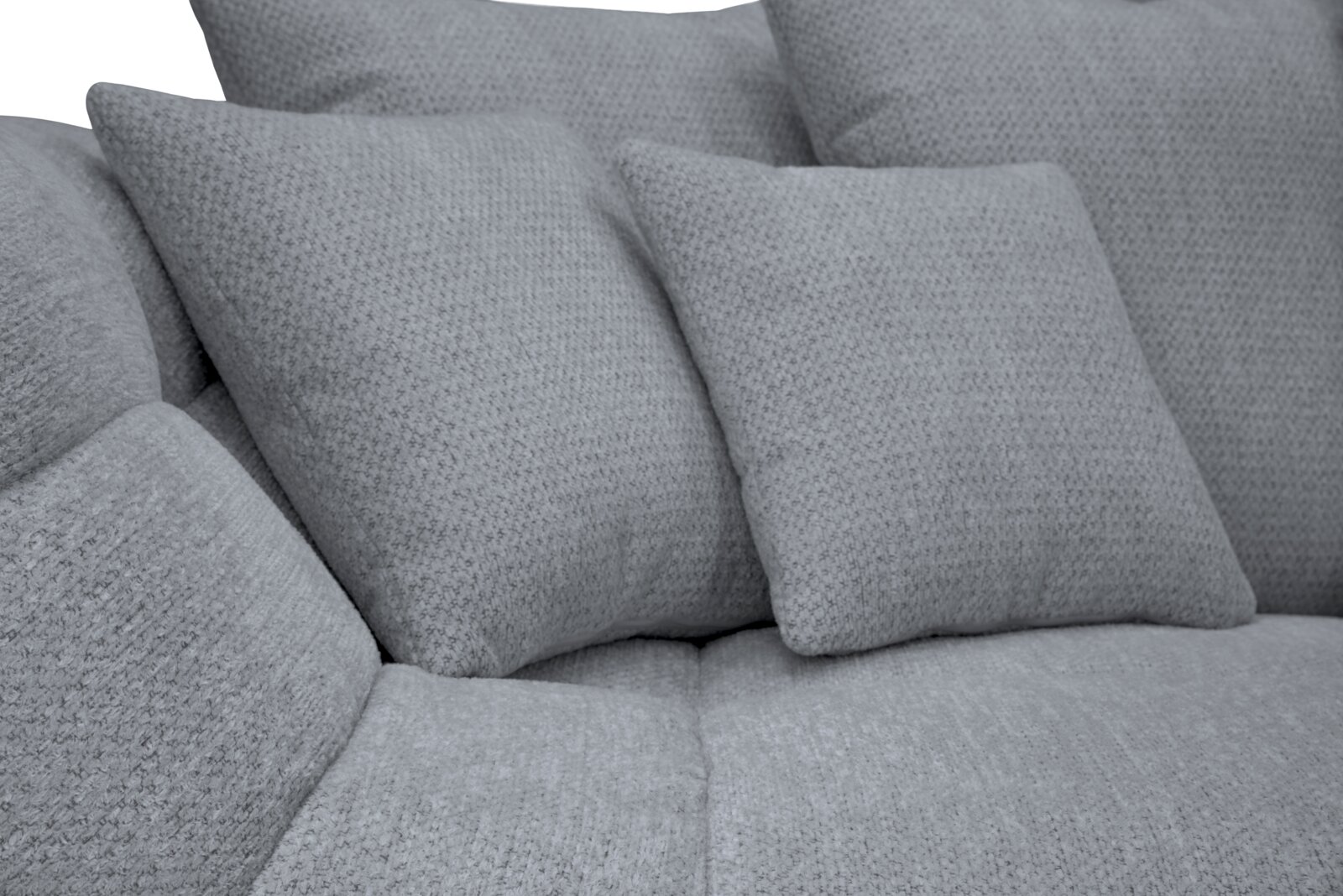 Detailaufnahme aus leicht schräger Vorderansicht: hellgraues, weich gepolstertes Sofa mit strukturierter Stoffoberfläche und zwei passenden Rückenkissen.