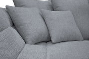 Detailaufnahme aus leicht schräger Vorderansicht: hellgraues, weich gepolstertes Sofa mit strukturierter Stoffoberfläche und zwei passenden Rückenkissen.