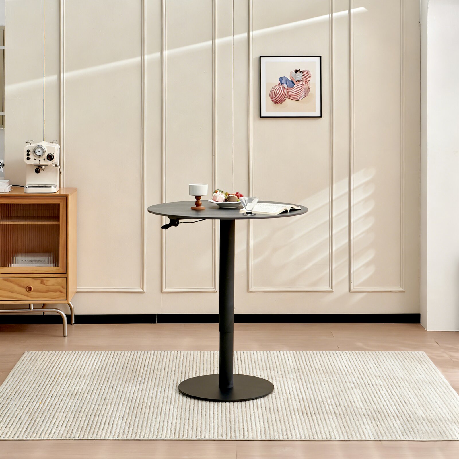Novel Eet-/bartafel DAVID - in hoogte verstelbaar Ronde bartafel in modern design, gezien vanaf de zijkant, op een tapijt, met decoraties zoals een kopje en een boek.