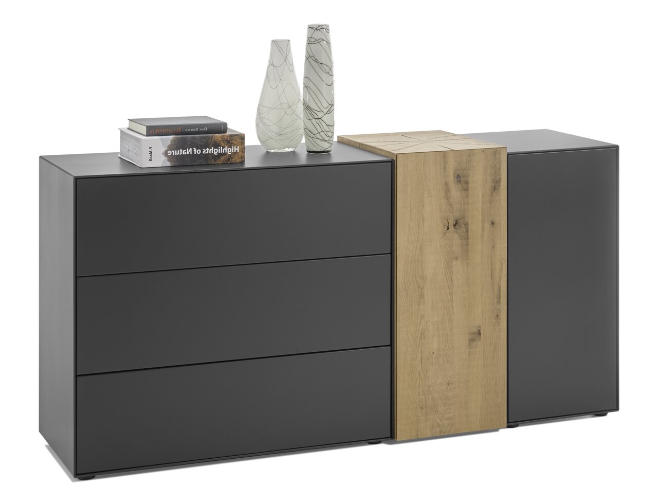 Musterring Dressoir TREVIO Modernes Sideboard in Schwarz mit drei Schubladen und einem Holzdetail, dekoriert mit Büchern und Vasen, seitliche Perspektive.